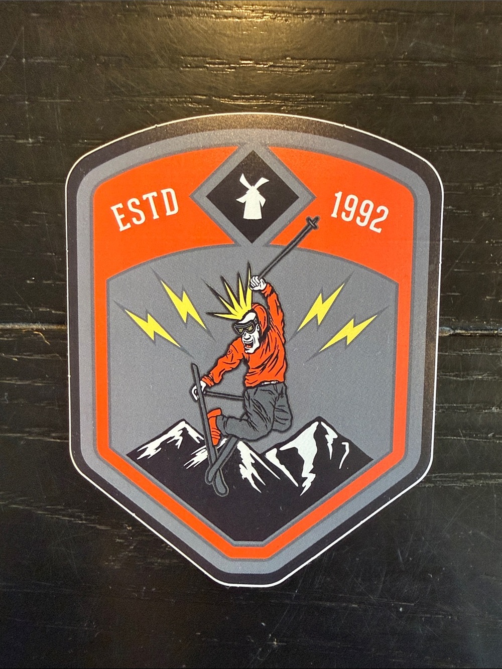 Dutch Bros ESTD 1992 Mountain Skier Badge Sticker - Orange & Gray